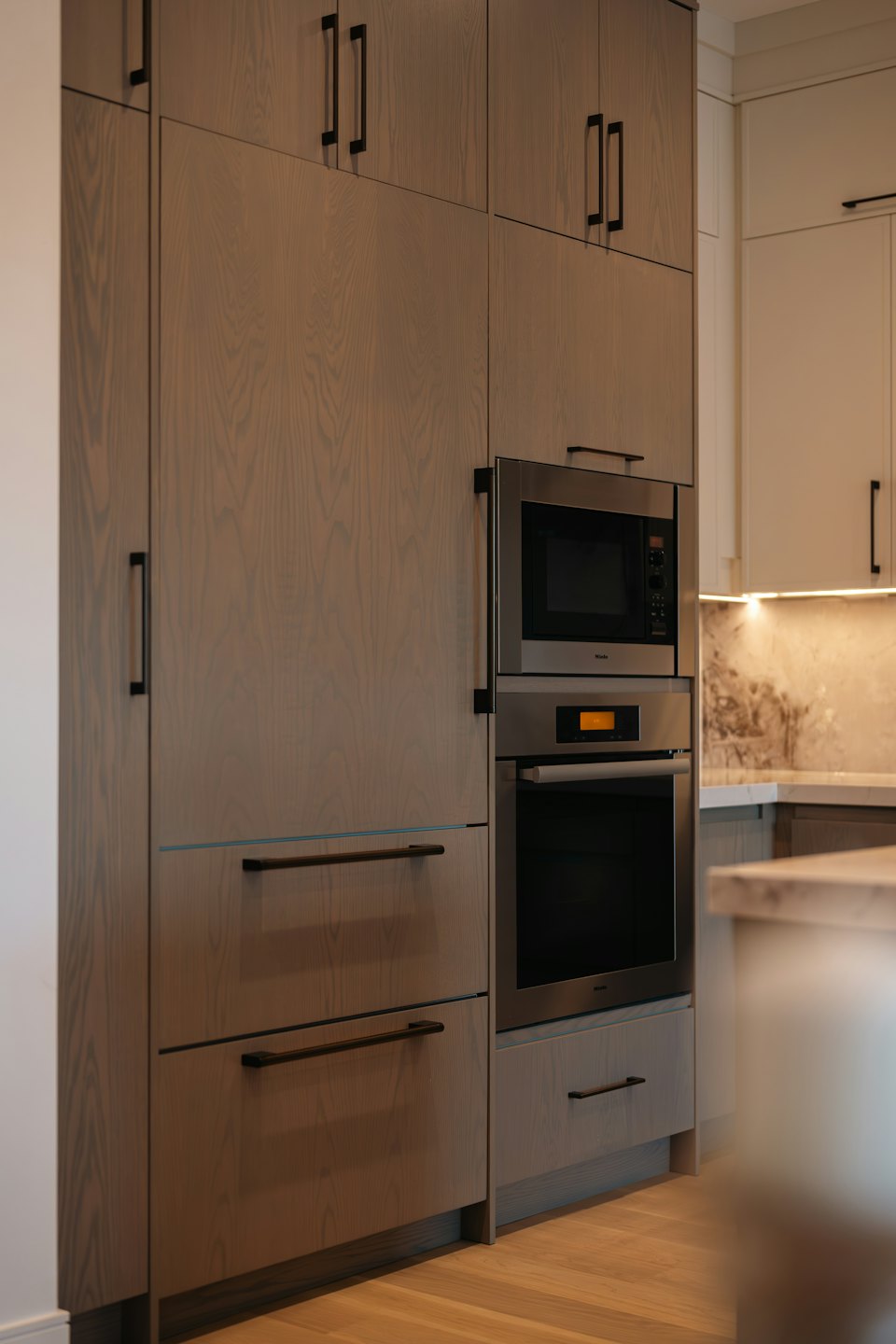 Cucina moderna con mobili in legno ed elettrodomestici in acciaio inox integrati.